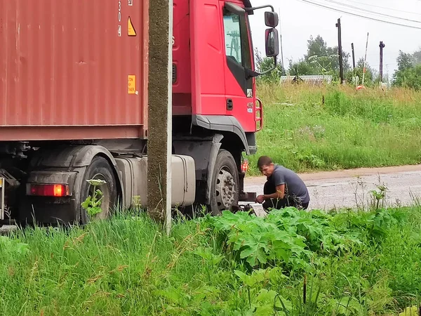 Kamyonun şoförü kazadan sonra farları tamir ediyor. Kuvshinovo, Tver bölgesi. 
