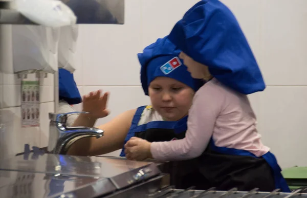 Pizzacı Dominos Pizza 'da pizza hazırlama sınıfındaki çocuklar. 