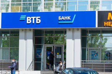  Alışveriş merkezindeki VTB Bank şubesi. Covid-19 salgını sırasında maskeli bir adam bankadan ayrılıyor..  