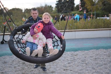 Babam Moskova 'daki Gorky Park' ta kızlarını salıncakta sallıyor..