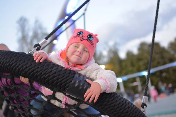 Outside in the warm time of the year a child plays on the Playground.