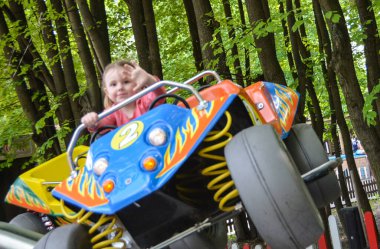 Bir çocuk lunaparkta ata biniyor.. 