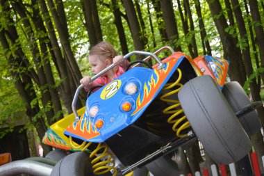 Bir çocuk lunaparkta ata biniyor.. 
