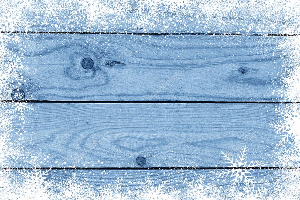 Blue Christmas winter background with snowflakes on wood