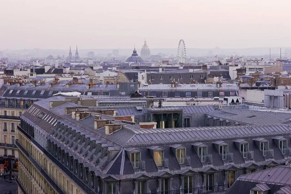 A beautiful top view of the Parisian buildings opens in the predawn haze.
