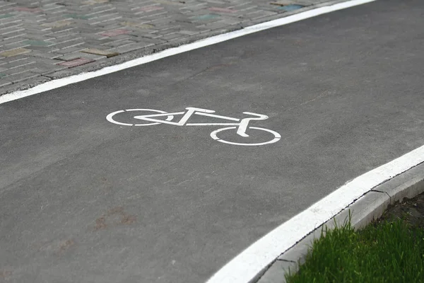 White bicycle sign with arrow on the asphalt, bike road sign on the street, bicycle lane sign on street, gray background