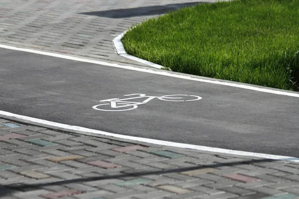 White bicycle sign with arrow on the asphalt, bike road sign on the street, bicycle lane sign on street, gray background
