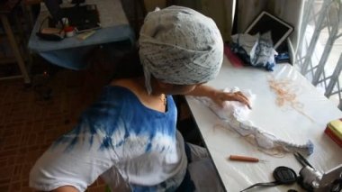 Taylandlı kadın emekçilerin Batik kravat doğal boyama renk süreci: Nonthaburi, Thailand atölyesinde kumaş üzerine bundle ve dikiş veya arashi shibori kat
