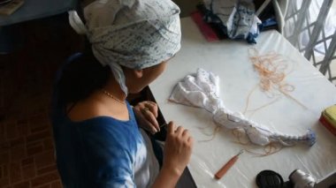 Taylandlı kadın emekçilerin Batik kravat doğal boyama renk süreci: Nonthaburi, Thailand atölyesinde kumaş üzerine bundle ve dikiş veya arashi shibori kat