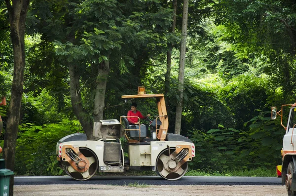 Tay işçilerin ağır makine inşaat alanı ile çalışma onarmak yol Kamphaeng Phet Historical Park, yüzeyi üzerinde 18 Temmuz 2017 yılında Kamphaeng Phet, Tayland