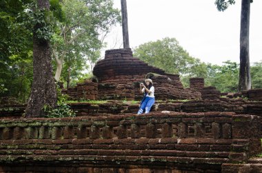 Ziyaret ve seyahat seyahat etmek Taylandlı kadın almak fotoğraf eski binada ve Kamphaeng Phet Historical Park kalıntıları bir arkeolojik sit ve Aranyik alanda Kamphaeng Phet, Tayland