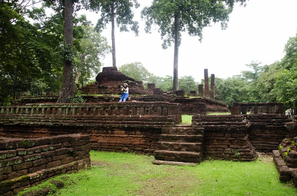 旅行者泰国妇女步行参观和旅行照相在古建筑和废墟烹 Phet 历史公园是一个考古学地点和 Aranyik 地区在烹 Phet — 图库照片