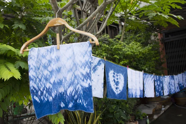 Handkerchief tie batik dyeing tie batik indigo color or mauhom color and hanging process dry clothes in the sun at garden outdoor in Nonthaburi, Thailand