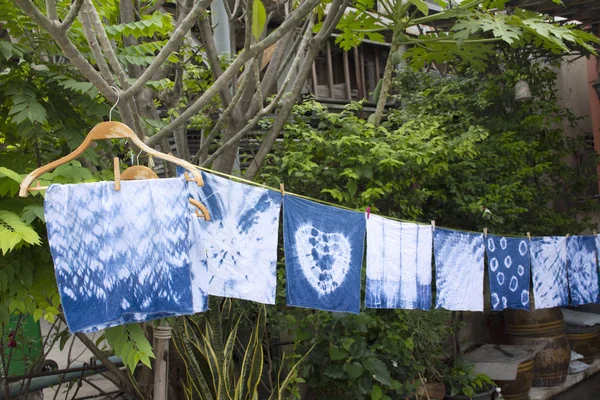 Handkerchief tie batik dyeing tie batik indigo color or mauhom color and hanging process dry clothes in the sun at garden outdoor in Nonthaburi, Thailand