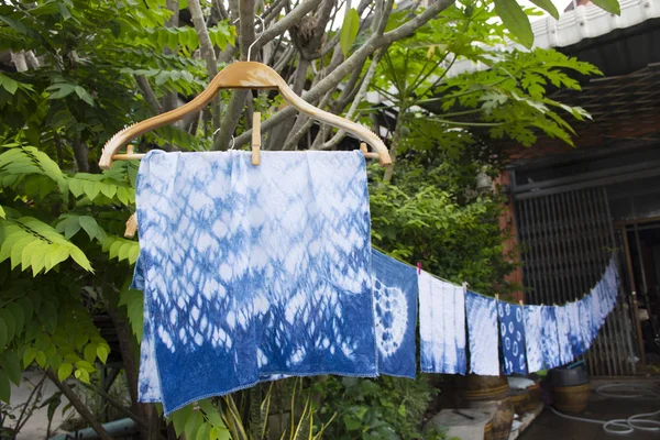 Handkerchief tie batik dyeing tie batik indigo color or mauhom color and hanging process dry clothes in the sun at garden outdoor in Nonthaburi, Thailand