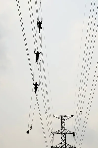 Electrician worker of Metropolitan Electricity Authority working repair electrical system on electricity pillar or Utility pole in countryside of Phra Nakhon Si Ayutthaya Province, Thailand