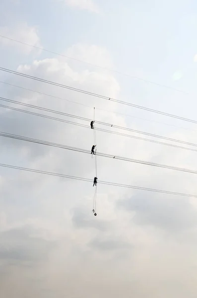 Electrician worker of Metropolitan Electricity Authority working repair electrical system on electricity pillar or Utility pole in countryside of Phra Nakhon Si Ayutthaya Province, Thailand