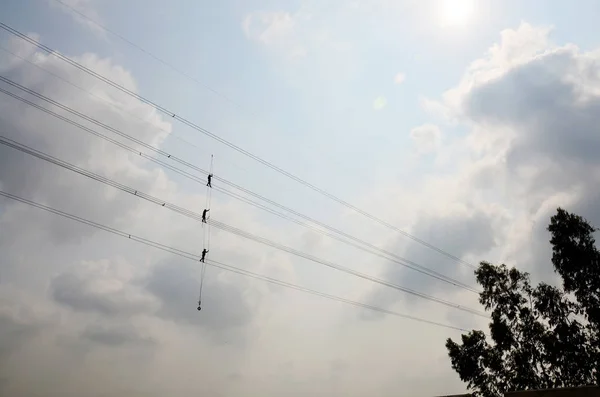 Electrician worker of Metropolitan Electricity Authority working repair electrical system on electricity pillar or Utility pole in countryside of Phra Nakhon Si Ayutthaya Province, Thailand