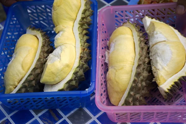 Thai people greengrocer peeling durian fruit for travelers people in fruits buffet festival at countryside between Chanthaburi to Rayong, Thailand