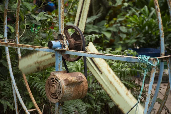 Old motor and big steel fan at outdoor for blowing cool down to travelers people in orchard garden on May 29,2018 in Rayong, Thailand