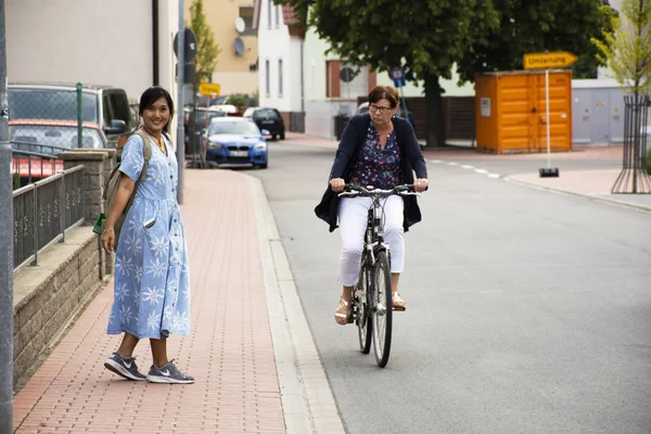 ドイツの女性人自転車に乗る自転車と道路の脇に Sandhausen 通り村の 2017 ドイツのハイデルベルクに歩いている出張タイ女性 — ストック写真