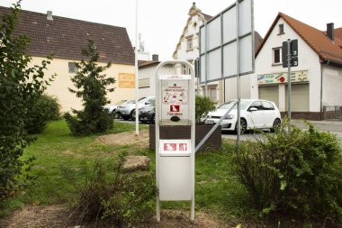 Etiket dikkat ve metal kutusu kullanılmak Alman halkının Sandhausen Köyü'nde 25 Ağustos 2017 Heidelberg, Almanya'daki bahçede köpek dumpage imha birimi hakkında