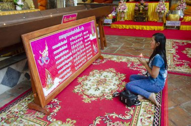 9 Şubat 2017 şarkı Buri, Tayland tarihinde büyük yatan Buda heykeli ubosot ya da Wat Phra sigara Chakkrasi Worawihan kilisede dua saygı oturan Taylandlı kadın.