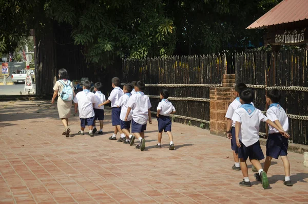 タイの学生の男の子と女の子スカウトの訪問と 2017 日を歌うブリ タイでのワット プラチェートゥポンウィモンマンカラーラーム花王トンまたは舞デーンの寺で仏像を祈って尊敬を歩く — ストック写真