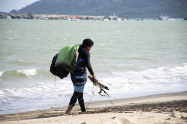 Tay erkek sporcular üzerinde kum plaj ve taşıma kiteboard yürüme yasağı Pae Plajı'nda pratik spor ve oynarken ya da deniz uçurtma için okyanus 3 Temmuz 2018: Rayong, Tayland gitmek