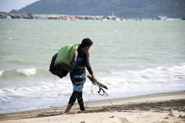 Tay erkek sporcular üzerinde kum plaj ve taşıma kiteboard yürüme yasağı Pae Plajı'nda pratik spor ve oynarken ya da deniz uçurtma için okyanus 3 Temmuz 2018: Rayong, Tayland gitmek