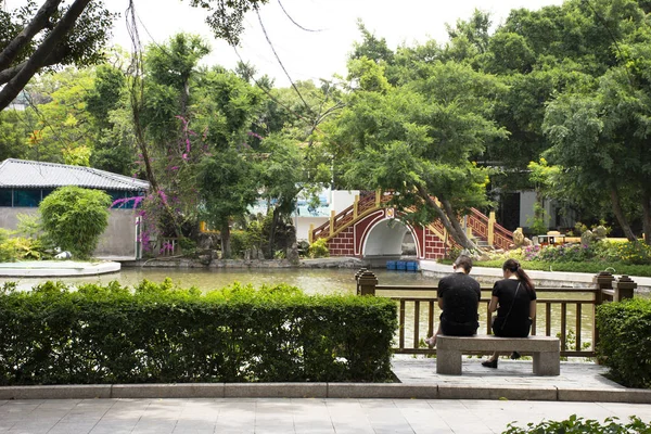 Chinês amante pessoas sentar no banco de pedra e relaxar no jardim um — Fotografia de Stock