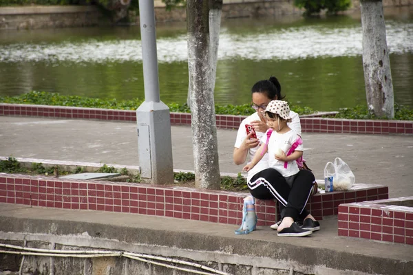 Китайцы и дети сидят отдохнуть в саду в Zhongshan Pa — стоковое фото