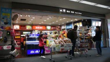 Tokyo, Japonya - 1 Nisan : Japon lar ve yabancı gezgin ler 1 Nisan 2019'da Tokyo, Japonya'da Chiba şehrindeki Narita Uluslararası Havaalanı'ndaki küçük bir dükkandan yiyecek ve hediyelik eşya hediye alıyor