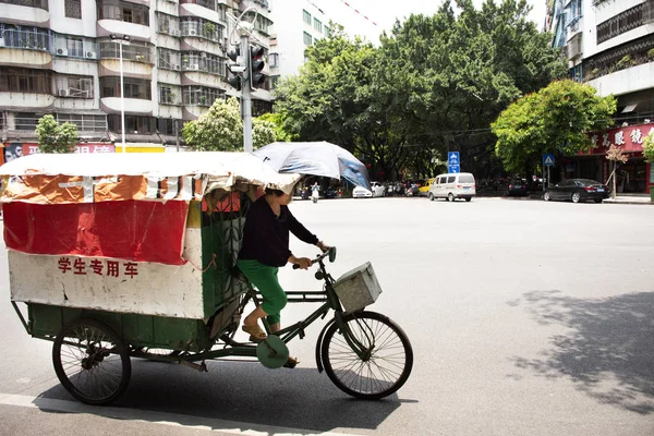 Chinese old woman ride trishaw with people drive car and ride mo — Stock Photo, Image