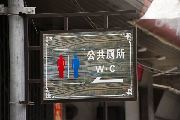 Wooden board or wood label for direct guide go to public toilet — Stock Photo, Image