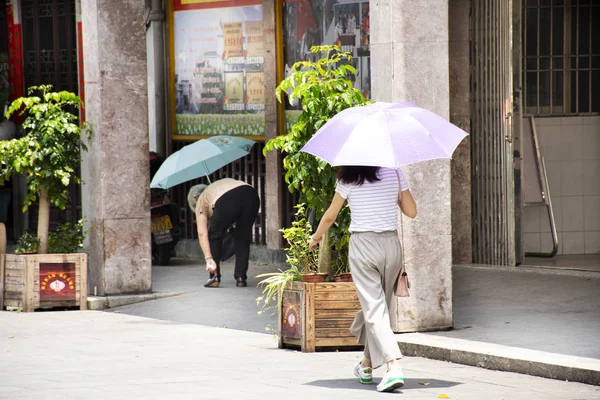 Chinesen und Ausländer mit Regenschirm zu Fuß — Stockfoto