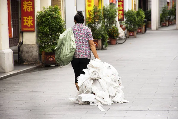 Chinese people old women dragging fertilizer sack on Paifang Str — Stock Photo, Image