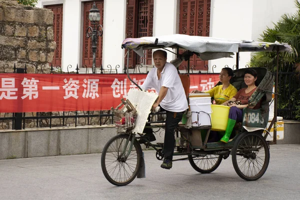 Китайцы ездят на велосипеде и тришо для привлечения иностранцев путешествовать — стоковое фото