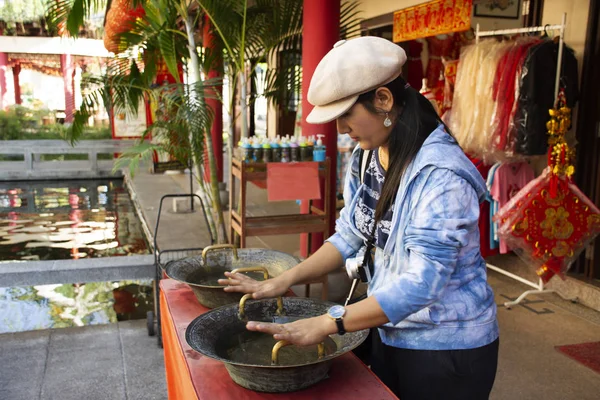 Mujer tailandesa frotando en la empuñadura de la mano de latón fregadero estilo chino para — Foto de Stock
