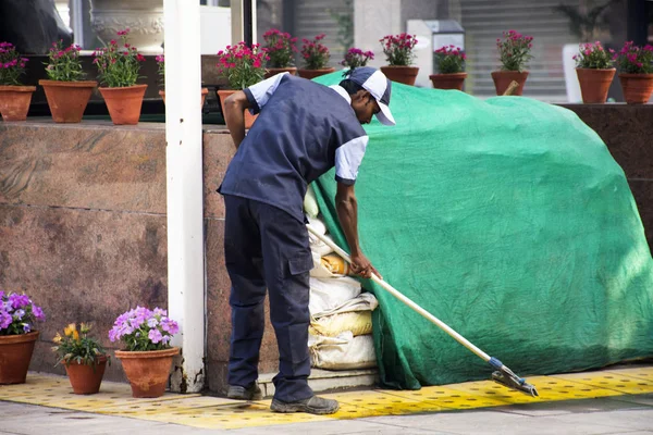 Los hombres indios limpiador limpiador piso en patio parque jardín de —  Fotos de Stock