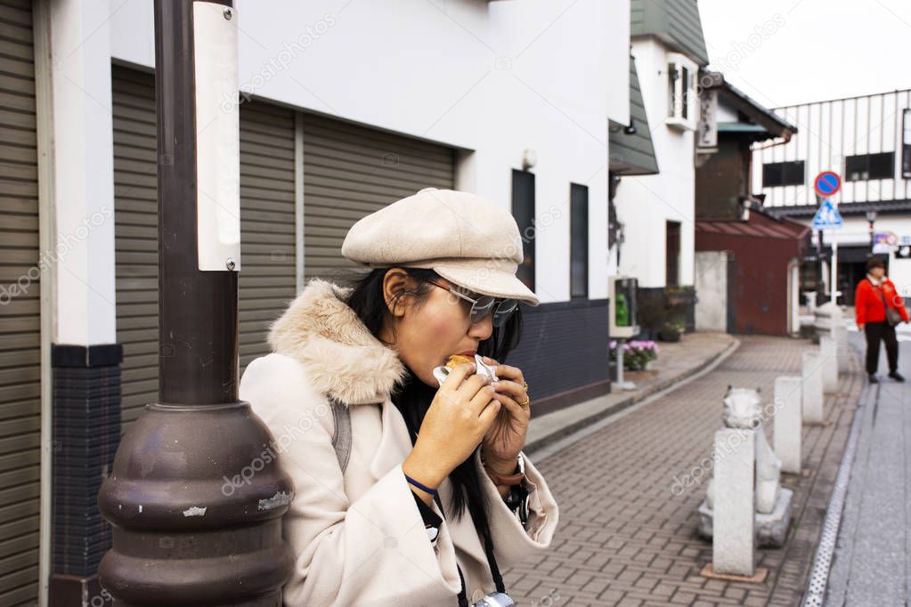 Traveler thai women travel visit and eating local japanese snack