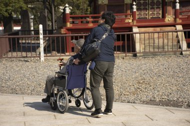 Japon aile halkı tekerlekli sandalye itmek ve yaşlı baba w getirmek