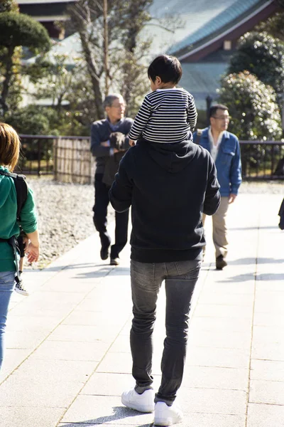 Giapponesi figlio cavalcare sul collo del padre a piedi visita e — Foto Stock