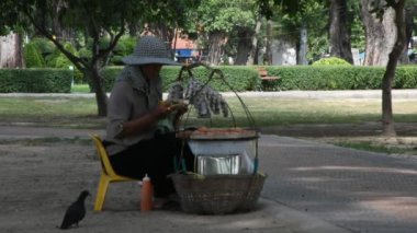 Songkla, Tayland - 17 Ağustos 2019 'da Songkhla, Tayland' da Samila Sahili 'nde gezginler için seyyar satıcı sepeti taşıyan yaşlı Taylandlı kadın satış elemanı