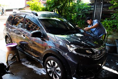 NONTHABURI, THAILAND - 17 Mayıs 2020 'de Tayland' ın Nonthaburi kentinde sabah saatlerinde insanların araba yıkama işi