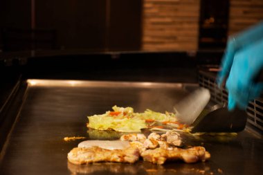 Tayland şefi kızarmış et ve sebze pişiriyor. Donburi Japon yemeği müşterisi. Tayland 'ın Nonthaburi kentindeki Bangyai şehrindeki modern restoranda servis yapmadan önce.
