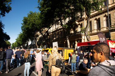 BUDAPEST, HUNGARY - 21 Eylül 2019 'da Macaristan' ın başkenti Budapeşte 'de Andrassy Bulvarı' ndaki panayır panayırında Macarlar ve yabancı gezginler yürüyüş yaparak içki içiyorlar.