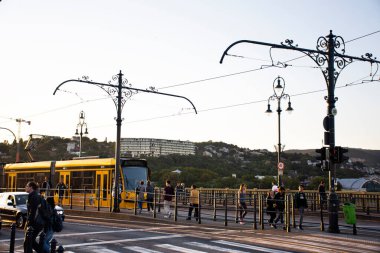 BUDAPEST, HUNGARY - 23 Eylül 2019 tarihinde Macaristan 'ın Budapeşte kentinde Elizabeth Köprüsü yolunun yanında, tren tramvayı, Macar yolcuları ve yabancı gezginlerin bulunduğu trafik yolu