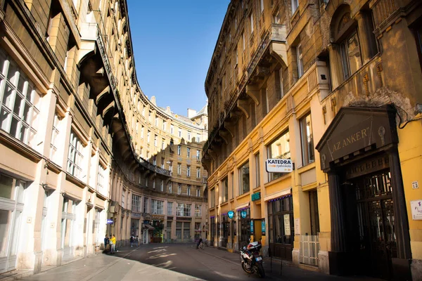 BUDAPEST, HUNGARY - 23 Eylül 2019 tarihinde Macaristan 'ın Budapeşte kentinde, Andrassy Bulvarı yolundaki klasik antika binayla küçük bir sokakta yürüyen Macarlar ve yabancılar