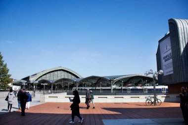 Alman halkı ve yabancı gezginler, 11 Eylül 2017 'de Almanya' nın Köln kentinde modern binalarla Köln veya kolonya Merkez Hauptbahnhof tren istasyonunun önünde yürüyüş ziyaretinde bulunuyorlar.